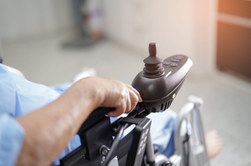 Patient auf elektrischen Rollstuhl mit Fernbedienung