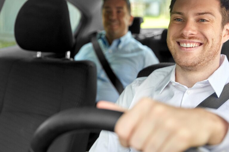 ein männlicher Taxifahrer, der ein Auto mit einem Fahrgast fährt